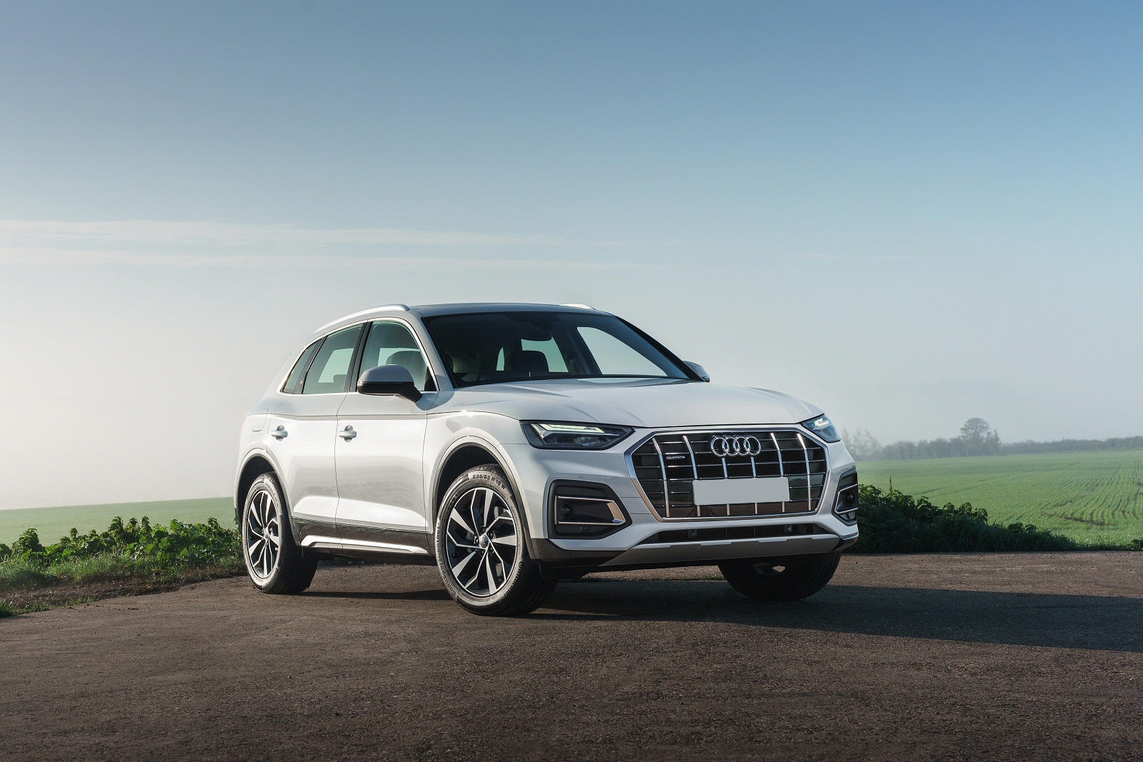 White Audi Q5 parked by a field